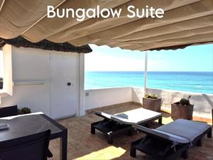 a patio with a table and chairs and the ocean at Mandala Bungalows - Adults Only in Los Caños de Meca