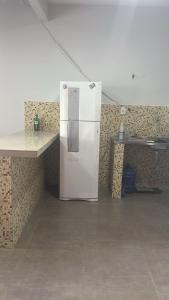 a white refrigerator in a room with a counter at Casa Salinas in Salinópolis