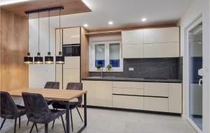 a kitchen with a wooden table and chairs at 1 Bedroom Beach Front Apartment In Silo in Šilo
