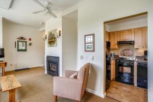 a living room with a chair and a kitchen at Lodge Condo 4 in Stowe Fork