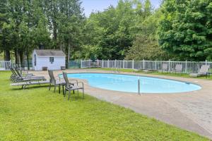 a swimming pool with two chairs and a house at Lodge Condo 4 in Stowe Fork