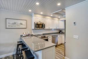 a kitchen with white cabinets and a granite counter top at Lodge Condo 16 in Stowe Fork