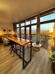 a living room with a wooden table and a large window at Cascadas in Antuco +11 photos