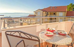 a table with two bowls of food on a balcony at Beautiful Apartment In Baska Voda in Baška Voda
