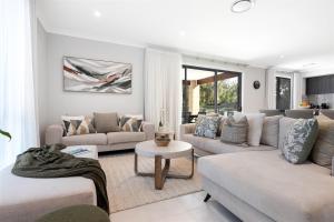 a living room with two couches and a table at Sunce Manyana Luxury home with pool and spa in Manyana