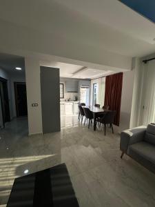 Una sala de estar con mesa y sillas y una cocina. en VILLA KoSAR, en Eskiömerler