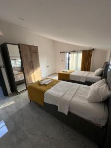 Una habitación de hotel con dos camas y un espejo. en VILLA KoSAR, en Eskiömerler