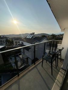 a balcony with two chairs sitting on top of a building at VILLA KoSAR in Eskiömerler