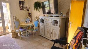 a dining room with a table and a white cabinet at Le Château de Soleil in Saint-Pons-de-Mauchiens