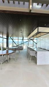 Un comedor con mesas y sillas y ventanas. en Studio moderno e completo Perto da Av, Beira Mar, en Fortaleza