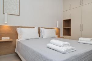 a bedroom with a white bed with towels on it at HESTIA frontyard Georgioupolis in Georgioupolis +24 photos