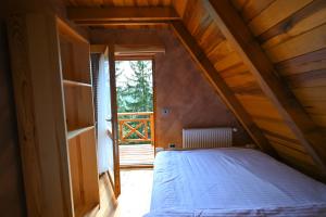 a bedroom with a bed in a wooden attic at Apartmani Vidaković - planina Zlatar, Nova Varoš, Srbija in Nova Varoš