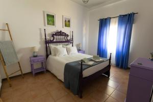 a bedroom with a large bed with blue curtains at Natur - Quinta Nª Srª da Conceição - T4 - Golegã in Golegã