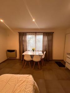 a bedroom with a table and two chairs and a window at Departamentos Lucinda in Ushuaia