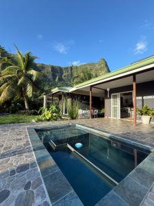 a swimming pool in front of a house at Fare Moorea in Moorea