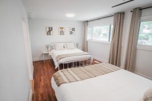 een slaapkamer met twee bedden en een raam bij Play & Stay - Downtown Sleeps 10 in Edmonton