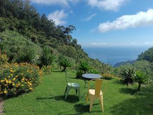 two chairs and a table in a field of grass at Arambha ecovillage farmstay in Tábua