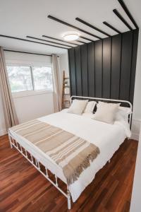 een slaapkamer met een wit bed en een zwarte muur bij Play & Stay - Downtown Sleeps 10 in Edmonton
