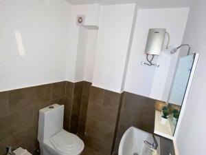 ミンデロにあるLazareto Oceanviewの白いトイレと洗面台のあるバスルーム +7枚の写真