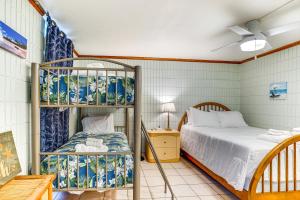 a bedroom with a bunk bed and a bed and a table at Beachfront Penthouse with 3 Lanais on Oahu! in Hauula +18 photos