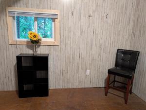 a black chair and a vase with a flower on a table at Sven's Basecamp Hostel in Fairbanks