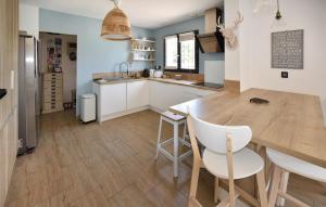 Una cocina con una mesa de madera y gabinetes blancos. en Maison Avec Piscine Privée, en Monteux