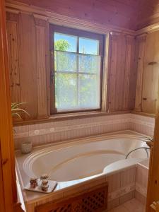 a bath tub in a bathroom with a window at Maris Berghütte Gerlitzen 1720m in Bodensdorf +40 photos