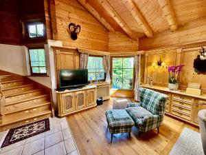 a living room with a television and a staircase at Maris Berghütte Gerlitzen 1720m in Bodensdorf