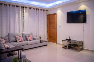un salon avec un canapé et une télévision à écran plat dans l'établissement Luxury Apartment, à San Pedro de Macorís