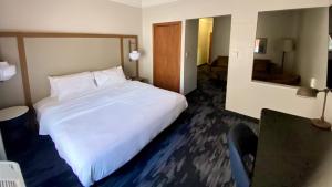 a bedroom with a large white bed and a mirror at Fairfield Inn and Suites New Buffalo in New Buffalo +1 photo