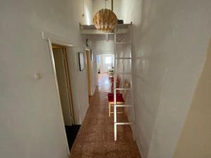 a hallway with a room with white walls and a shelf at Casa na aldeia in Albernoa