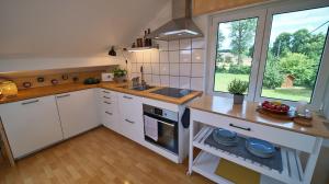 a kitchen with white cabinets and a sink and a window at Treetop Apartment - Schwarzwald und Schwäbische Alb in Eutingen