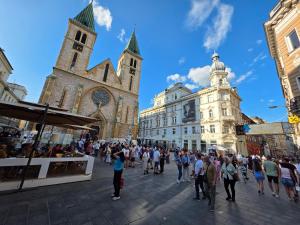 サラエボにあるFerhadija Living APARTMENTSの大聖堂の前の通りを歩く人々の群れ