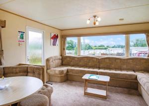 a living room with a couch and a table at Woodland Vale Holiday Park in Ludchurch
