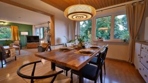 a kitchen and dining room with a wooden table and chairs at Plant Apartment - Großer Balkon mit Grill - Schwarzwald und Schwäbische Alb in Eutingen