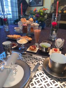 a table topped with plates of food and drinks at Chambres d'hôtes Le Regent in Hyères