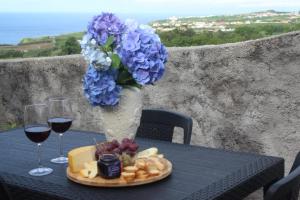 a table with a plate of food and a vase with blue flowers at Vista Horizonte in Salga
