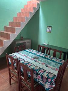 a table and chairs with a table and a staircase at Casa simples e confortavel, próx ao centro de pelotas in Pelotas