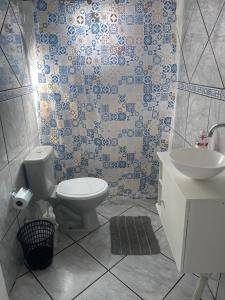 a bathroom with a toilet and a sink at Casa simples e confortavel, próx ao centro de pelotas in Pelotas +16 photos