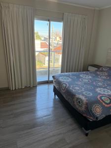 a bedroom with a bed and a large window at Temporario alquiler por día semana o mes in Junín
