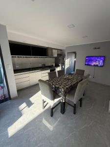 a dining room with a table and chairs and a television at Temporario alquiler por día semana o mes in Junín