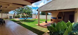 a patio of a house with a yard with a swimming pool at Suites Quartos Lindos Sobrado com Piscina no Centro in Campo Grande