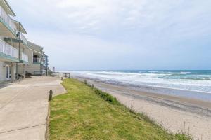 a sidewalk next to a beach with the ocean at Pool and Hot Tub Ground Floor Studio - Oceanfront - Full Kitchen - Patio in Lincoln City