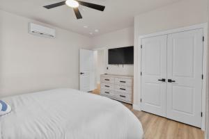 ein weißes Schlafzimmer mit einem Bett und einem Deckenventilator in der Unterkunft Modern Loft Getaway 25 Min to Zion, Walk to Food and Parks in Hurricane