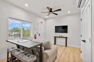 ein Wohnzimmer mit einem Deckenventilator und einem Tisch in der Unterkunft Modern Loft Getaway 25 Min to Zion, Walk to Food and Parks in Hurricane
