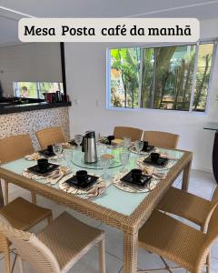 a dining room table with chairs and a tableclotholitics at Carpevie Casa temporada Muro Alto in Ipojuca