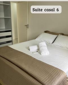 a bed with two white towels on top of it at Carpevie Casa temporada Muro Alto in Ipojuca