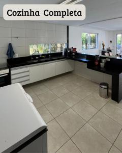 a kitchen with a black and white counter top at Carpevie Casa temporada Muro Alto in Ipojuca +4 photos