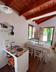 eine Küche mit Tisch und Esszimmer in der Unterkunft Las Camellias in La Cumbre