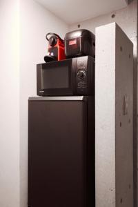 a microwave and a camera on top of a refrigerator at Shirogane Apartment in Tokyo